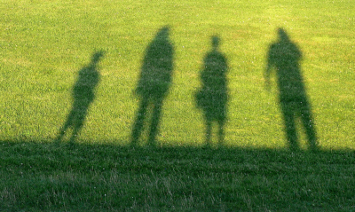 Shadow of family on grass
