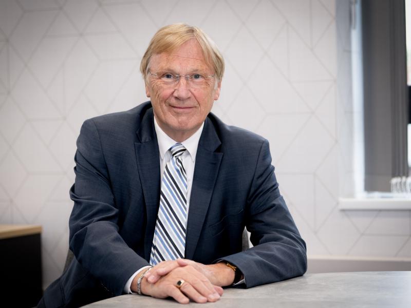 Councillor Ian Courts sits at a desk. 