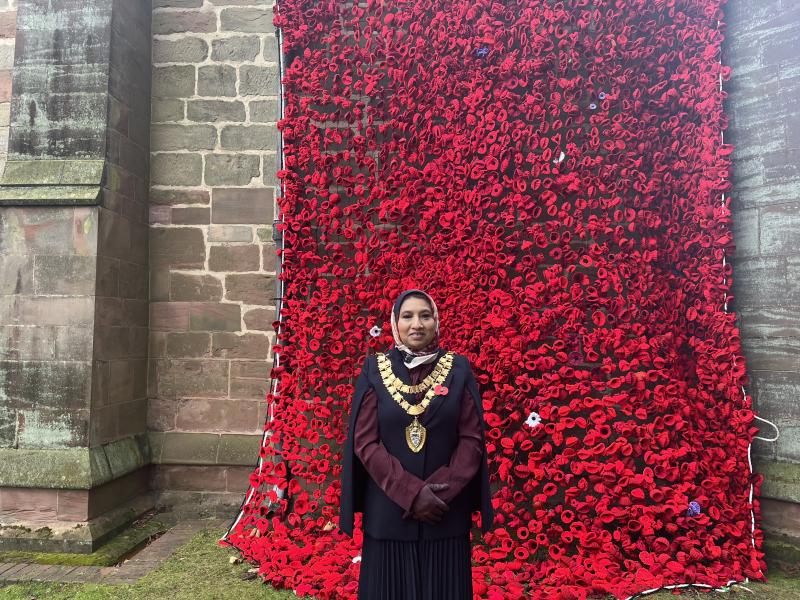 The Mayor of Solihull standing next to the St Alphege Church poppies display