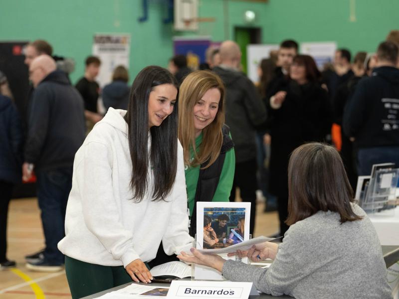 A young person and her parent learning about apprenticeships at a previous apprenticeship show