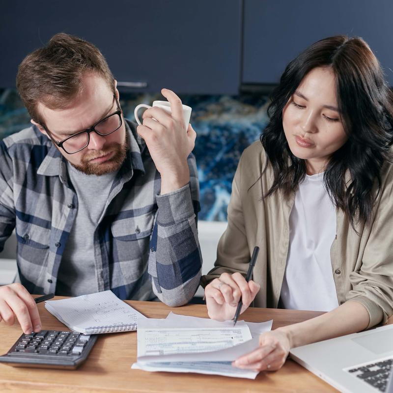 photo of couple with bills and calculator